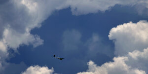 Ein Segelflugzeug fliegt durch eine Wolkenlücke.