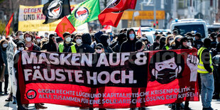 Menschen stehen hinter einem Banner auf einer Demo