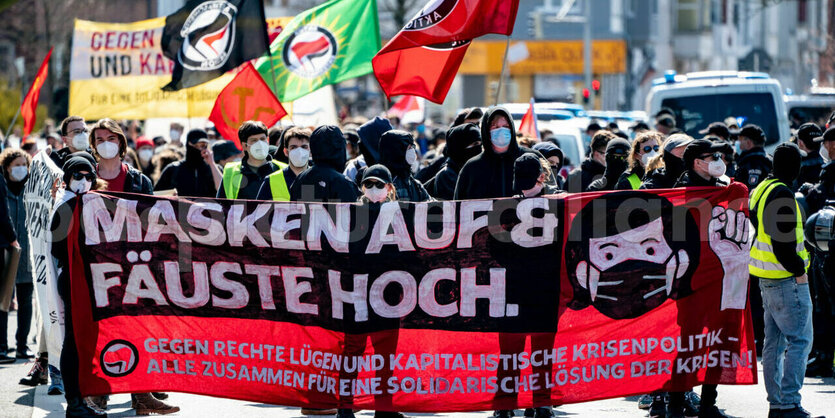 Menschen stehen hinter einem Banner auf einer Demo