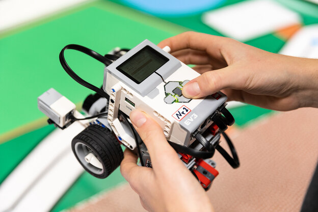 Maxim hält den Mini-Roboter in der Hand Maxim hält den Mini-Roboter in der Hand