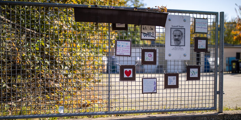 Holztafeln an einem Zaun, eine mit dem Abbild des vom NSU ermordeten Ismail Yasar