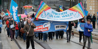 Zwei DemnostrantInnen stehen bei einer Demo unter Regenschirmen mit der Aufschrift 2nein Zum Krieg"
