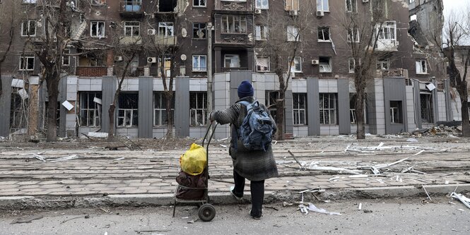 Eine Anwohnerin vor einem zerstörten Wohnhaus in Mariupol