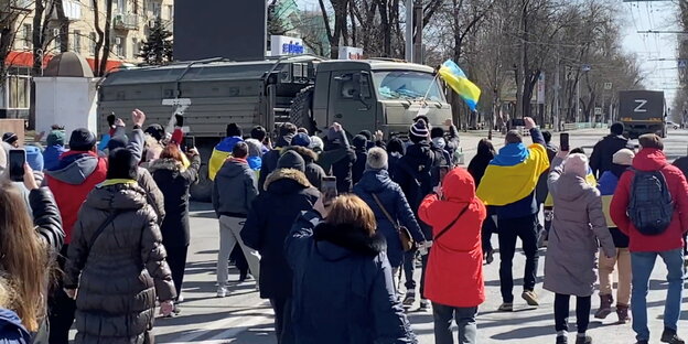 Ukrainer demonstrieren vor russischen Militärfahrzeugen