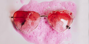 Eine rosa Brille, die Gläser in Herzform