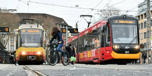 zwei Straßenbahnen stehen an einer Haltestelle