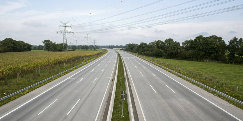 Zwei Spuren Autobahn führen durch eine platte Landschaft