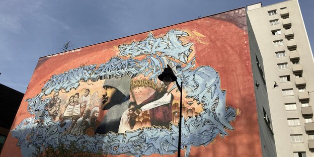 Graffitti für die Einwanderung an einer Hochhauswand