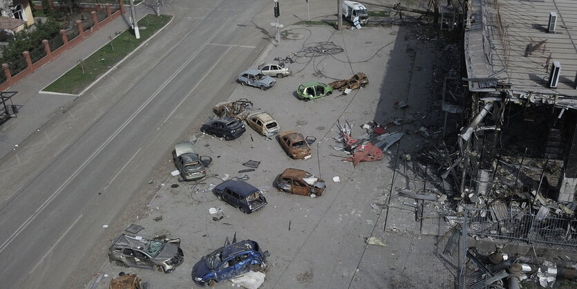 demolierte Autos auf einem Bürgersteig, eine leergefegte Strasse