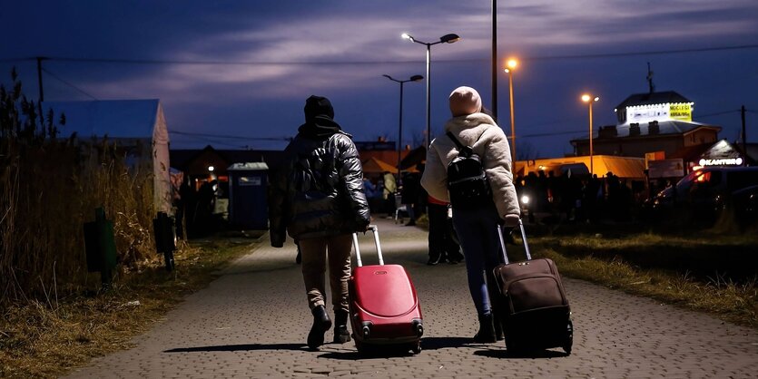 Zwei Frauen mit Koffern bei Nacht