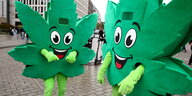 Zwei Personen verkleidet als Cannabis-Blätter