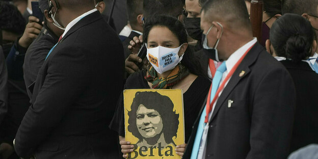 Eine Frau hält ein Plakat mit dem Portrait der Umweltaktivistin Berta Caeres