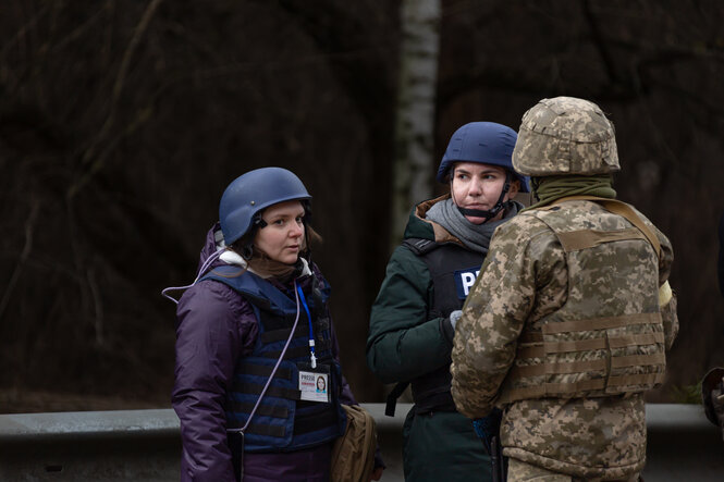 Die Journalistinnen Anastasia Magasowa (l.) und Tetiana Bezruk sprechen mit einem ukrainischen Soldaten