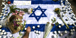 Kerzen auf einer Israelflagge nach dem Attentat in Tel Aviv