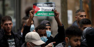 Ein Demonstrant hält eine Palästinafahne auf der "Free Palestine - Boycott Israel" geschrieben steht