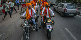 Hindus in traditionellen Gewändern fahren auf Motorrädern