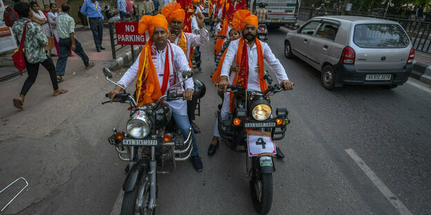 Hindus in traditionellen Gewändern fahren auf Motorrädern