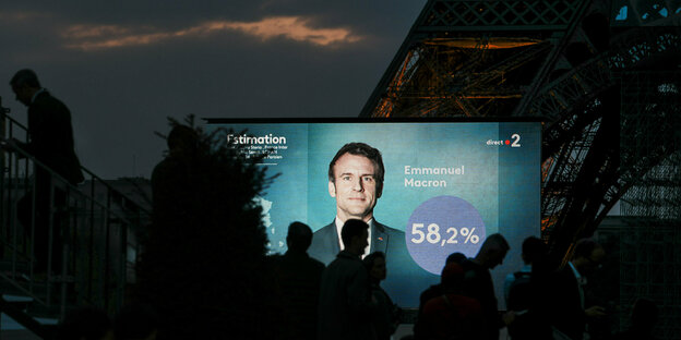 Eine Videoleinwand vorm Eiffelturm zeigt Emmanuel Macron und das Wahlergebnis