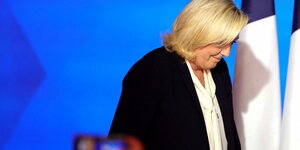 Le Pen seitlich schaut zu Boden, die Haare verdecken ihr Gesicht