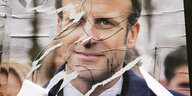Bemaltes und halb abgerissenes Wahlplakat mit dem Portrait vn Macron