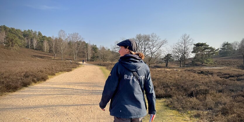 Rangerin Anne Jüngst geht auf einem Weg durch die Fischbeker Heide.