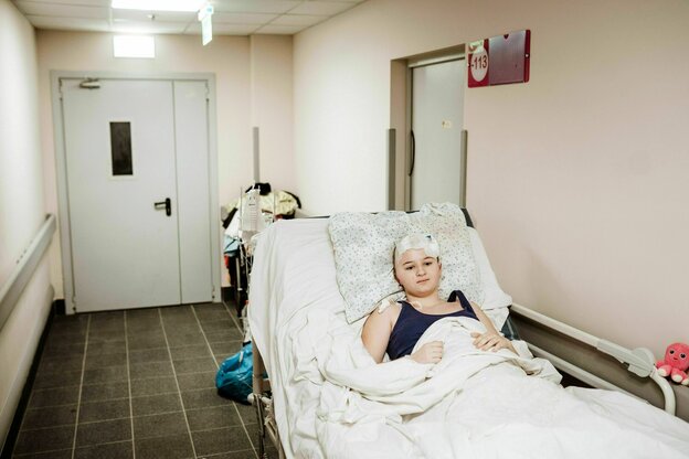 Ein Kind liegt mit einem Kopfverband in einem Klinikbett Ein Kind liegt mit einem Kopfverband in einem Klinikbett