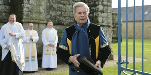 vincent Bollore in einer tradionellen Uniform, im Hintergrund Kirchenvertreter