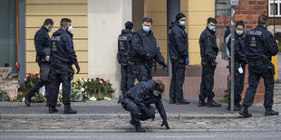 Eine Gruppe von Polizisten su8cht auf einer Straße nach Spuren