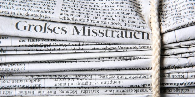 Viele Zeitungen, eine Zeitung hat die Worte "Großes Misstrauen" in einer Überschrift in einer
