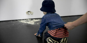 Der einjährige Noa schaut sich beim Gallery Weekend Berlin das Werk "I... I... I..." von Ryan Gander in der Galerie Esther Schipper an, wobei er von seiner Mutter an der Jacke gehalten wird.