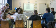 Kinder sitzen in einem Klassenzimmer mit dem Blick zur Tafel