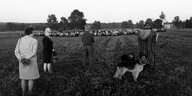 Schwarz-Weiß-Foto mit Menschen auf einer Wiese