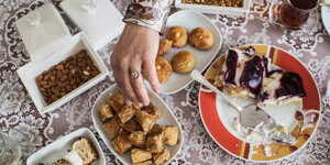 Asse trinkt mit einer Freundin Tee und isst besondere Süßigkeiten zum Zuckerfest. Für Millionen Muslime endet mit dem Feiertag Eid al-Fitr am Donnerstag der heilige Fastenmonat Ramadan