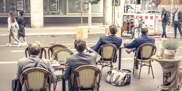 Menschen sitzen auf Stühlen auf der Friedrichstraße