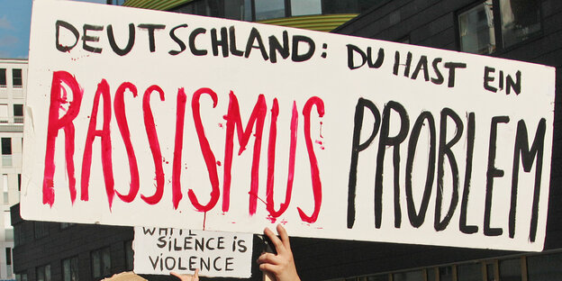 Ein Schild auf einer Demonstration auf dem steht: Deutschland: Du hast ein Rassismusproblem