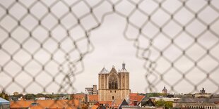 Blick durch einen Maschendraht auf den Braunschweiger Dom