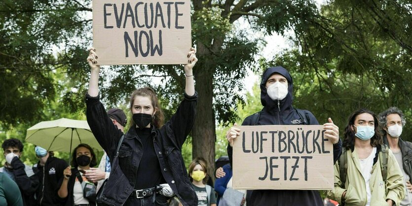 Demonstranten mit Schildern, auf denen steht: "Luftbücke jetzt" und "Evacuate now"