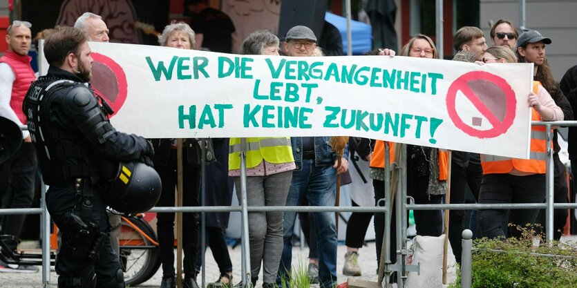 Menschen mit einem Banner: "Wer die Vergangenheit lebt, hat keine Zukunft"