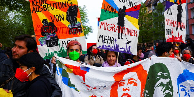 Menschen stehen hinter einem Fronttransparent auf einer Demo