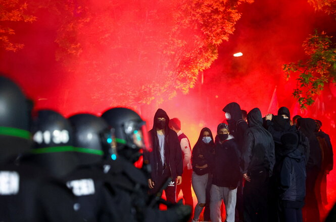 Polizisten stehen vor einem rot erleuchteten Himmel