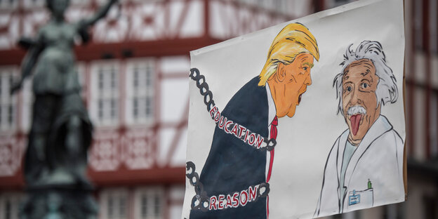 Einen in Ketten gelegten US-Präsidenten Donald Trump und den Nobelpreisträger Albert Einstein zeigt ein Plakat am 22.04.2017 beim sogenannten "March for Science" in Frankfurt am Main.