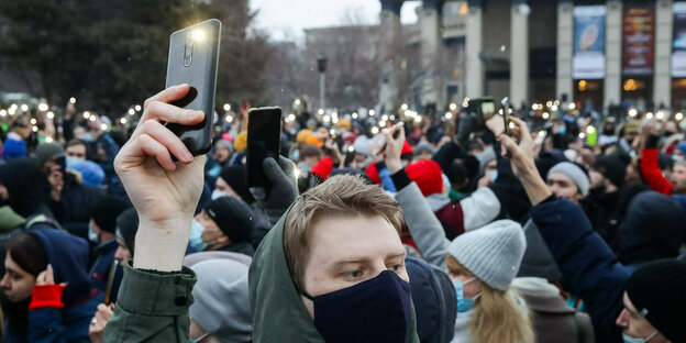 Menschen in einer Menge halten ihre Smartphones in die Höhe