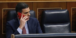 Pedro Sanchez sitzt im Plenarsaal und telefoniert