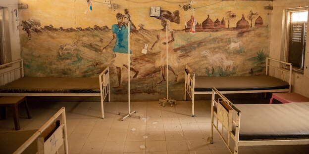 Krankenbetten vor einer Wand mit einem Wandgemälde
