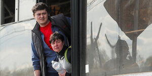 Zwei Menschen schauen aus einem Bus