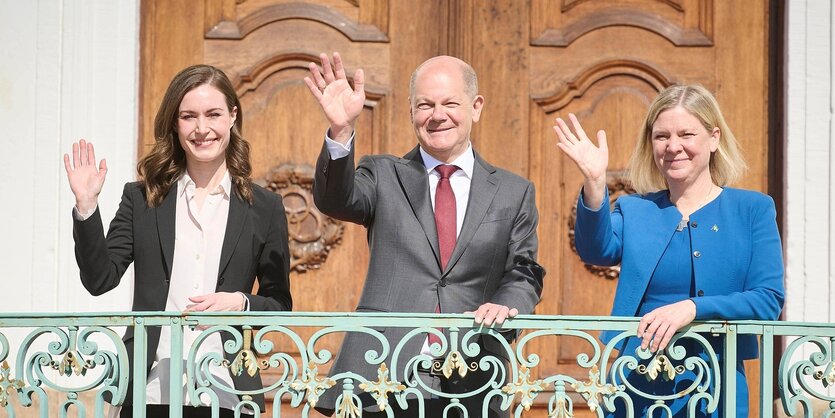 Finlands Ministerpräsidentin Sanna Marin, Bundeskanzler Olaf SCholz und die Ministerpräsidentin von Schweden, Magdalena Anderson stehen auf einem Balkon und winken