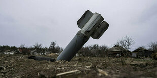 Eine Rakete steckt im Boden nahe einer Ortschaft in der Ukraine