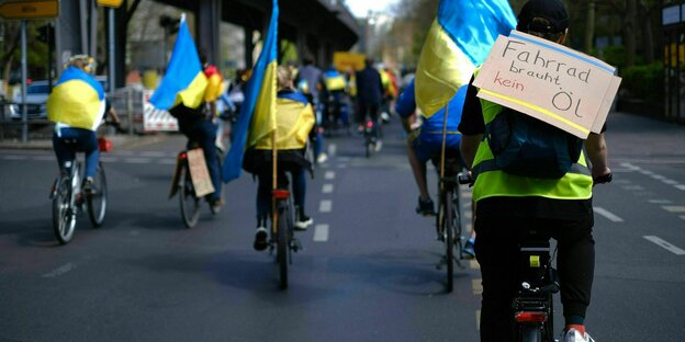 Fahrradkorso mit ukrainischen Flaggen und dem schild: Fahrrad braucht kein Öl