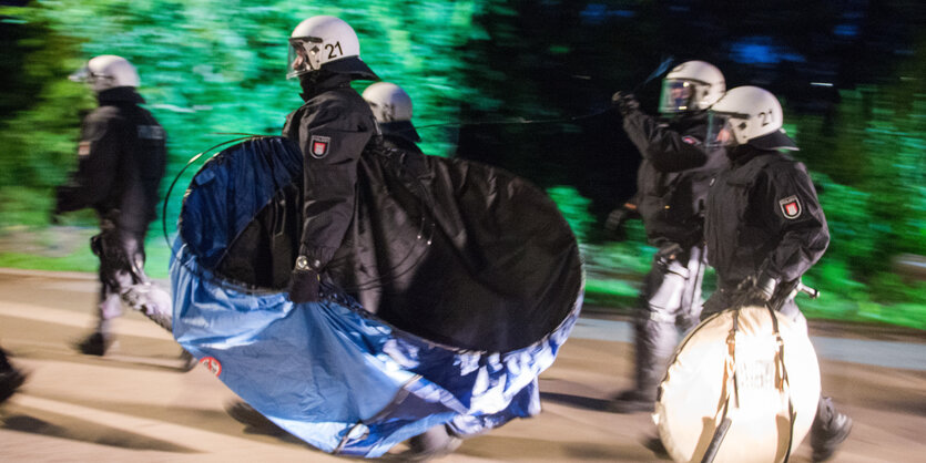 Polizistinnen und Polizisten tragen Wurfzelte