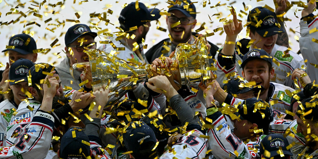 Die Berliner Eishockeyspieler jubeln mit dem Meisterpokal